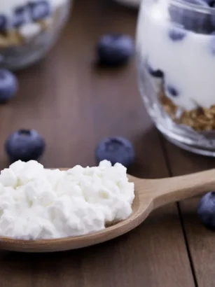 A bowl of milk kefir surrounded by kefir grains and a historical background.